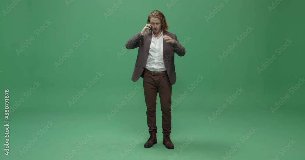 Studio, slow motion, green screen, a frustrated young man on the phone, London, UK Studio, slow motion, green screen, a frustrated young man on the phone, London, UK