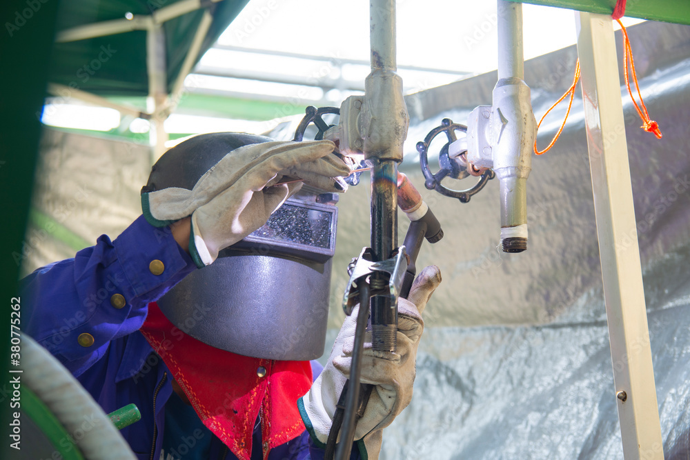 The welder is welding the steel pipe to the valve with Tungsten Inert