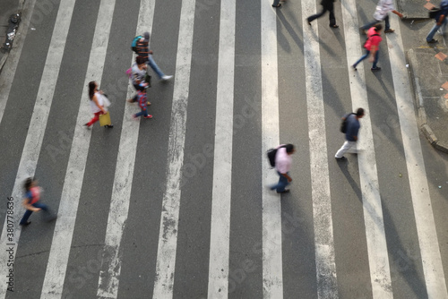 Crowd of pedestrians crossing busy intersection photo