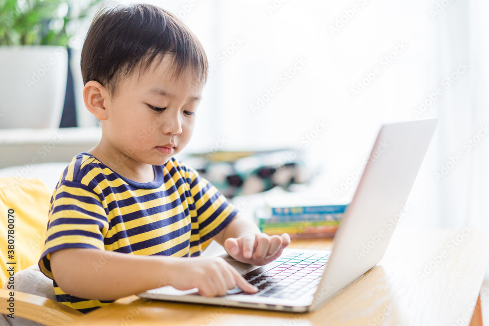 Asian toddler boy student study online learning online education video call zoom teacher.Happy boy learn english online with laptop at home.New normal.Covid-19 coronavirus.Social distancing.stay home. Asian toddler boy student study online learning online education video call zoom teacher.Happy boy learn english online with laptop at home.New normal.Covid-19 coronavirus.Social distancing.stay home.