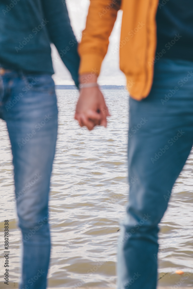 Couple holding hands on a background of lake (defocussed) Couple holding hands on a background of lake (defocussed)