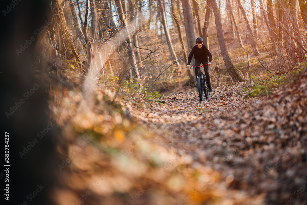 Young man riding mountain bike through forest Young man riding mountain bike through forest