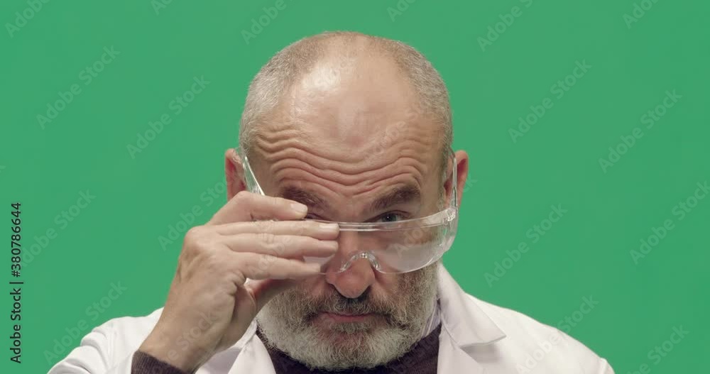 Studio, slow motion, green screen, a mature man puts on his safety glasses, London, UK Studio, slow motion, green screen, a mature man puts on his safety glasses, London, UK
