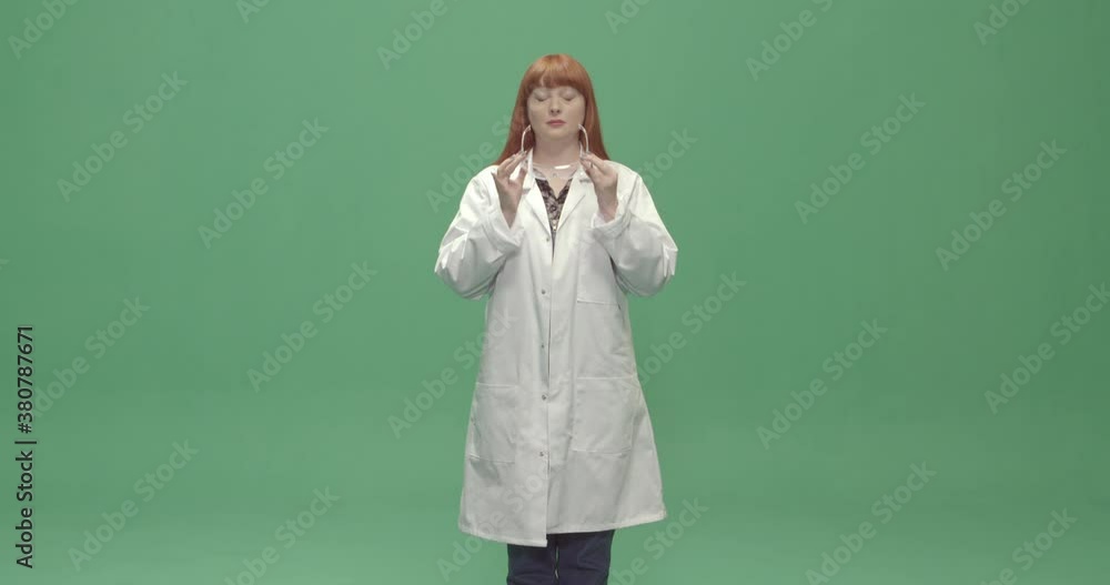 Studio, slow motion, green screen, a young woman takes off her safety glasses, London, UK Studio, slow motion, green screen, a young woman takes off her safety glasses, London, UK