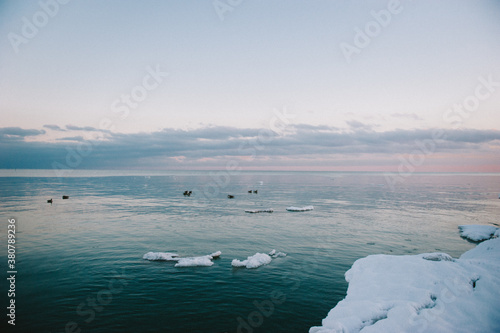 Purple and blue cloudy sky at sunset over frozen winter lake photo