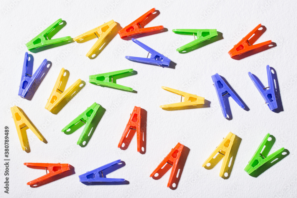 Colorful plastic clothespins for hanging clothes on white background