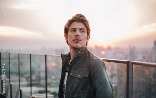 Young man on a rooftop at sunset photo