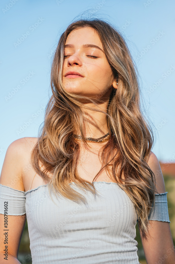 Portrait of blonde young woman at sunset