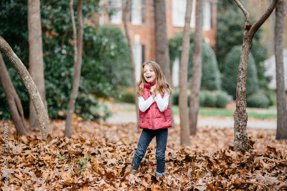 Adorable young girl standing in a bed of leaves Adorable young girl standing in a bed of leaves