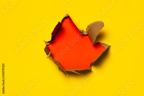 Papel roto amarillo intenso. Fondo del agujero de rotura. Concepto mínimo abstracto de papel pintado colorido. photo