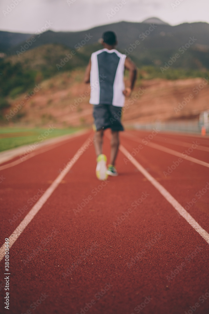 Black guy from behind jogging on a track Black guy from behind jogging on a track