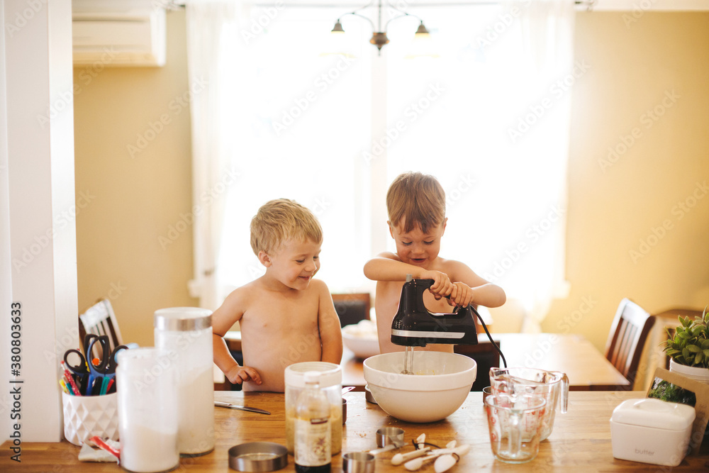 3 year old caucasian boys baking together at kitchen bar 3 year old caucasian boys baking together at kitchen bar