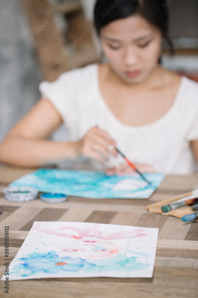 Portrait of beautiful young Asian woman painting with gouache in Portrait of beautiful young Asian woman painting with gouache in