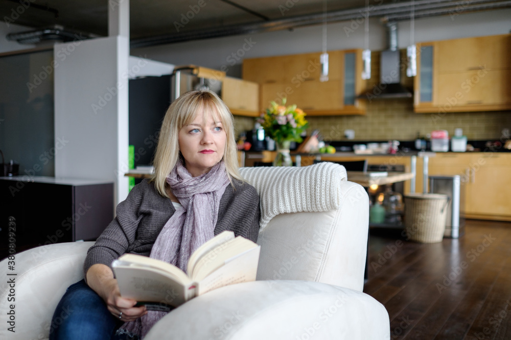 Woman relaxing by reading a book at home Woman relaxing by reading a book at home