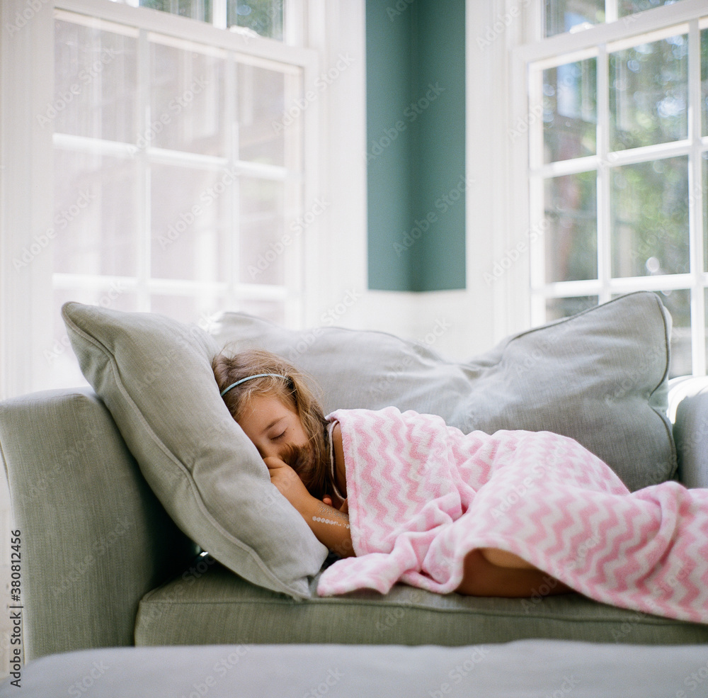 Young girl sleeping with a blanket in an over sized chair Young girl sleeping with a blanket in an over sized chair