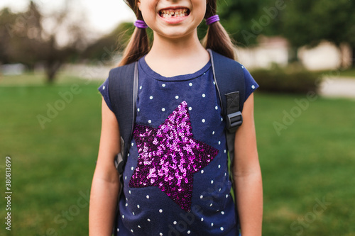 Six year old girl showing off her first missing tooth