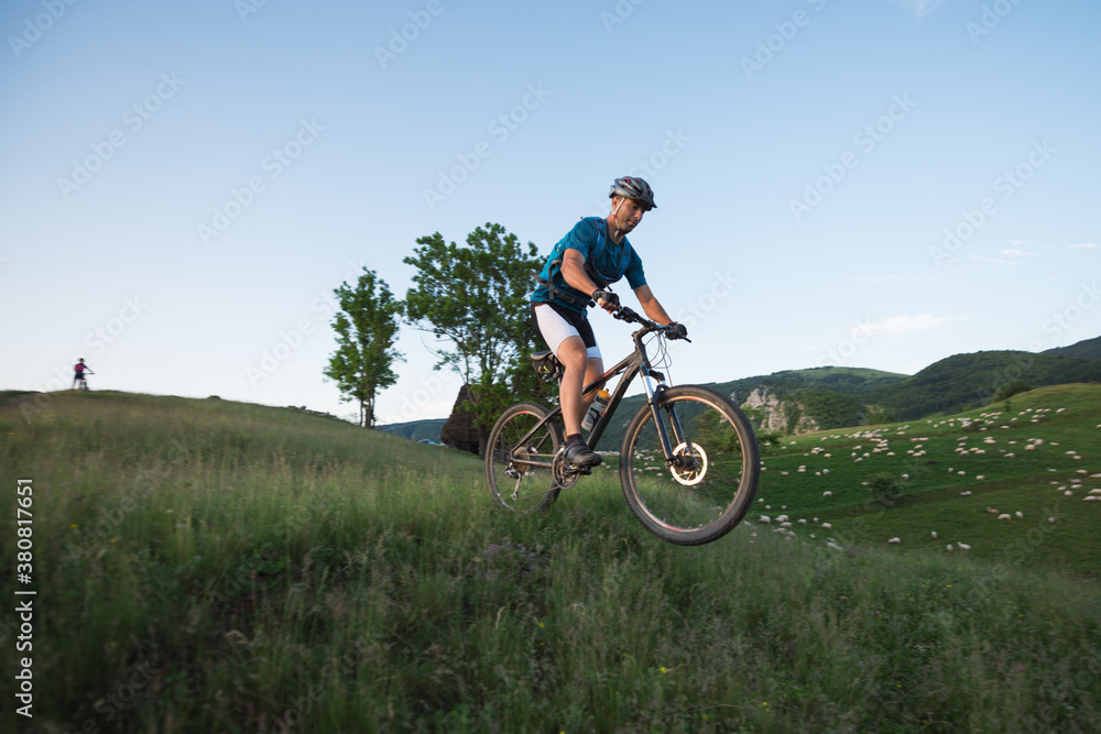 Young man doing a trick with his mountain bike Young man doing a trick with his mountain bike