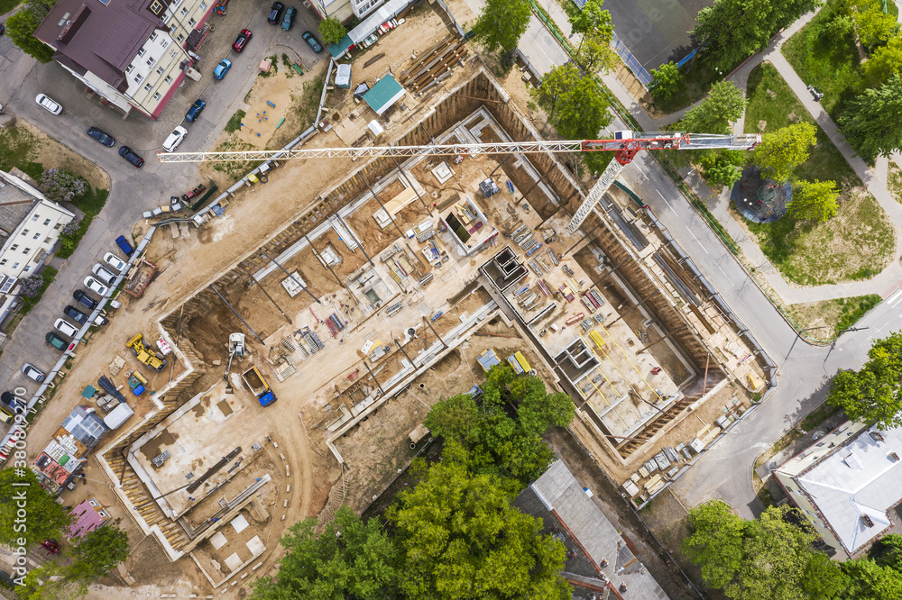 aerial view over a construction site with crane in city residential area