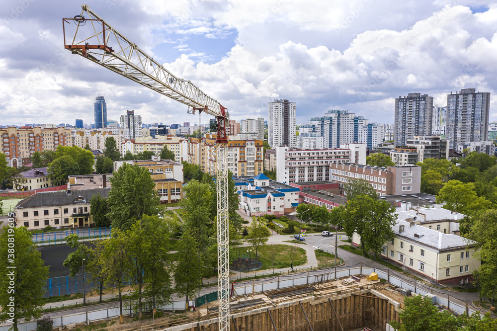 construction site in a city residential area. tower crane against blue cloudy sky. drone point view construction site in a city residential area. tower crane against blue cloudy sky. drone point view