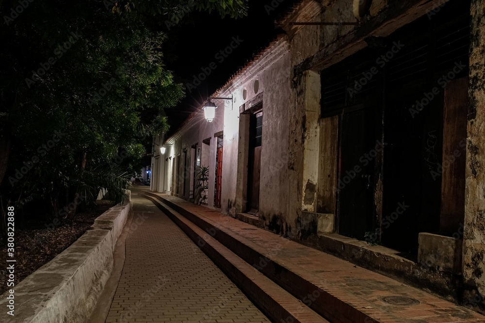 View to typical one story buildings at night in light of lanterns at the promenade of, Santa Cruz de Mompox, Colombia, World Heritage View to typical one story buildings at night in light of lanterns at the promenade of, Santa Cruz de Mompox, Colombia, World Heritage