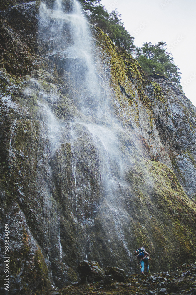 Hiker below a waterfall Hiker below a waterfall