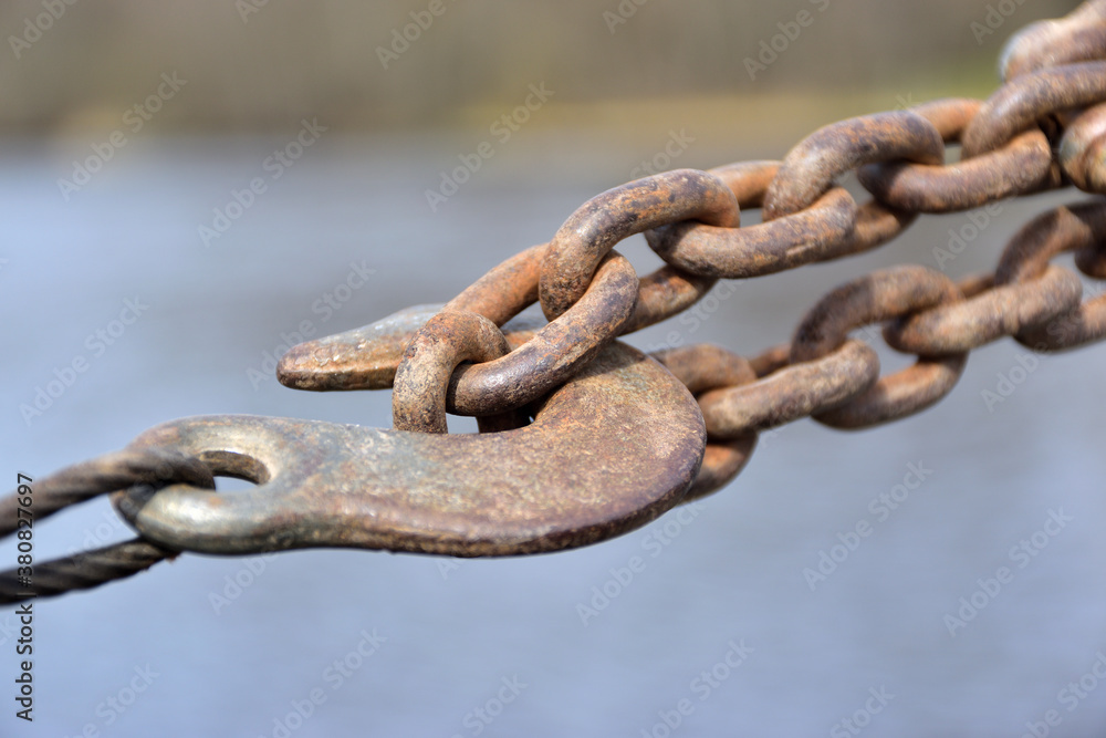 Rusty chain with a hook stretched on a pier Rusty chain with a hook stretched on a pier