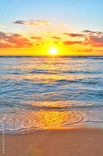 Sun setting on the ocean at Waikiki beach in Honolulu on Oahu, Hawaii. 