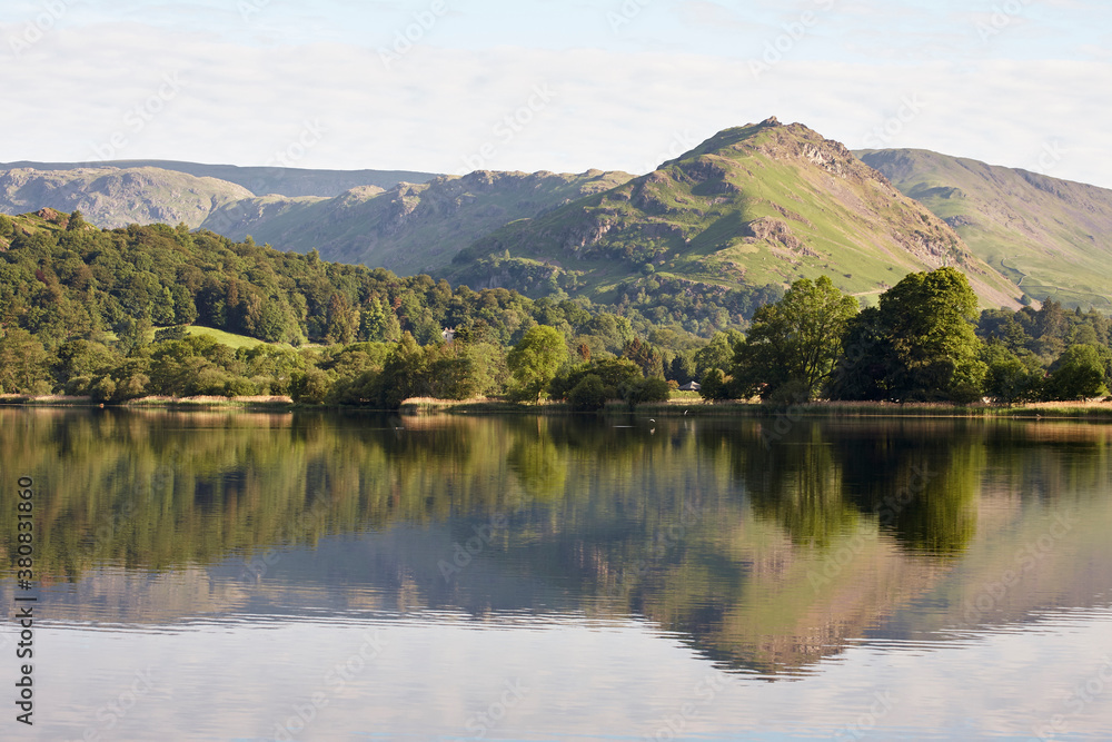 Helm Crag and reflections on the surface of Grasmere lake at sunrise. Cumbria, UK. Helm Crag and reflections on the surface of Grasmere lake at sunrise. Cumbria, UK.