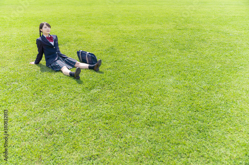 草原に座る女子高生
