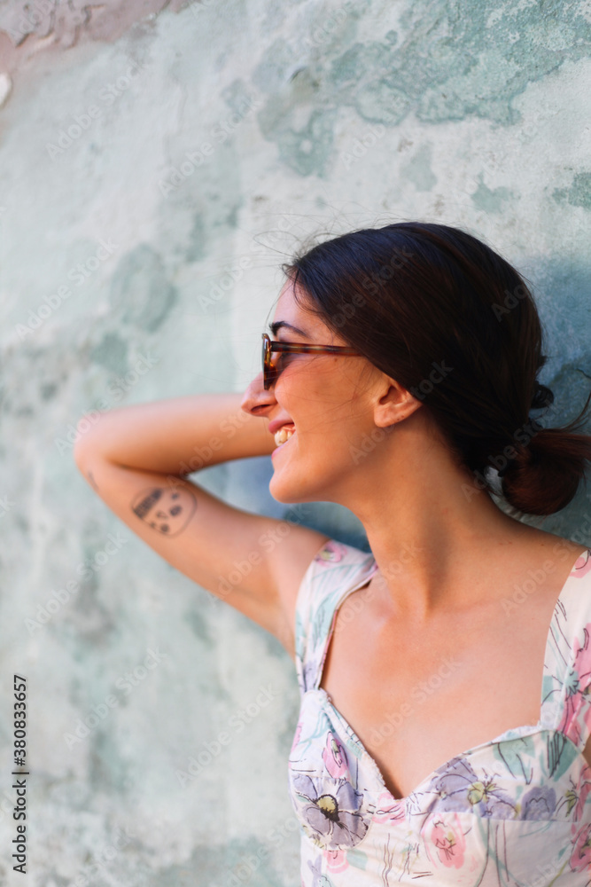 Attractive woman smiling in fron of a rural wall Attractive woman smiling in fron of a rural wall
