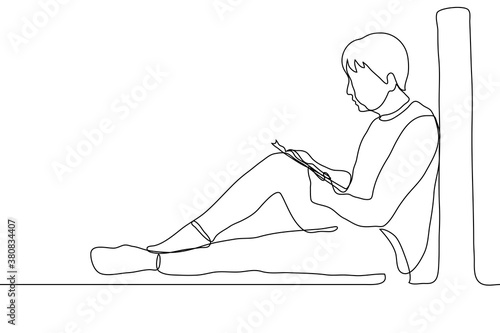 full-length man sits on the windowsill of a large window reading a book, he put a book / textbook / notebook on his knee. one line drawing concept of reading alone