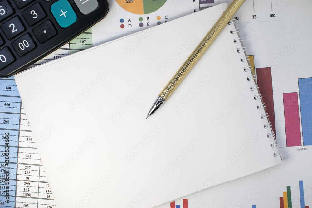 Charts and graphs that contain a calculator and a blank Notepad with a gold pen. Business concept Charts and graphs that contain a calculator and a blank Notepad with a gold pen. Business concept