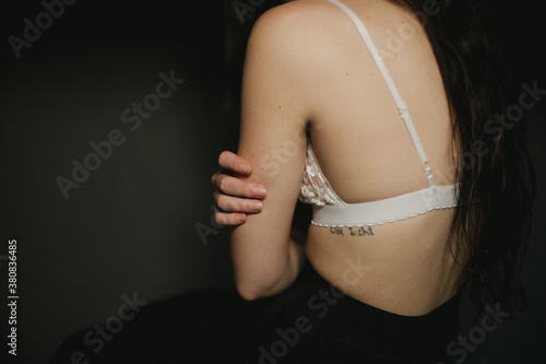 Skinny girl wearing white bra with boney spine showing photo