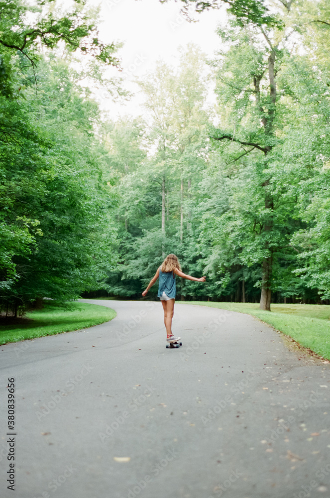 Teen girl riding on a longboard Teen girl riding on a longboard