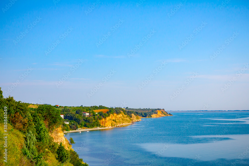 Cliff with vegetation above idyllic and peaceful bay