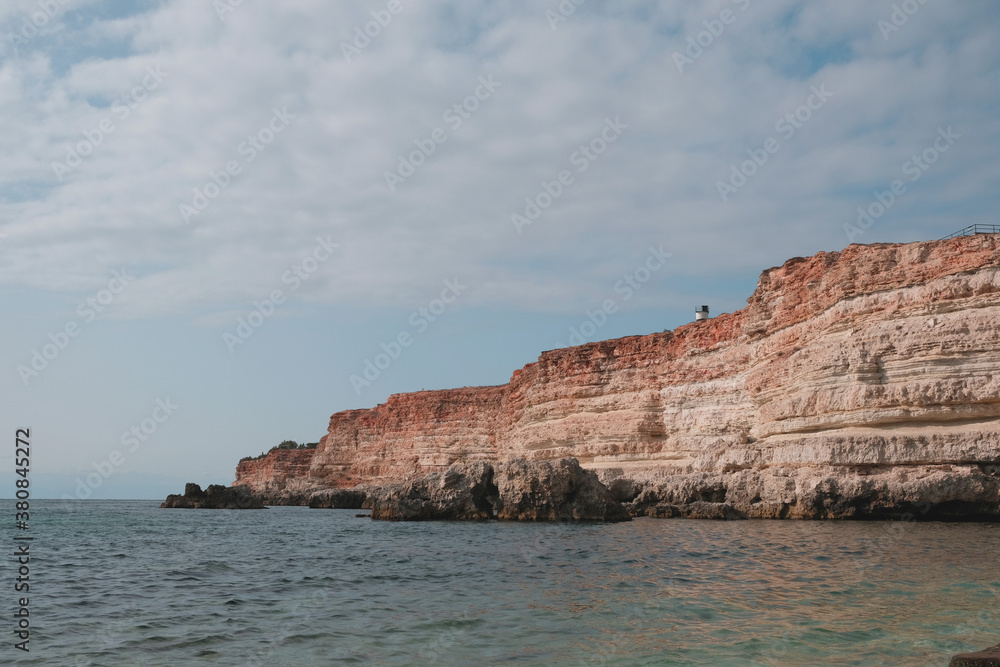 Silky blue sea waves with a stone shore.
