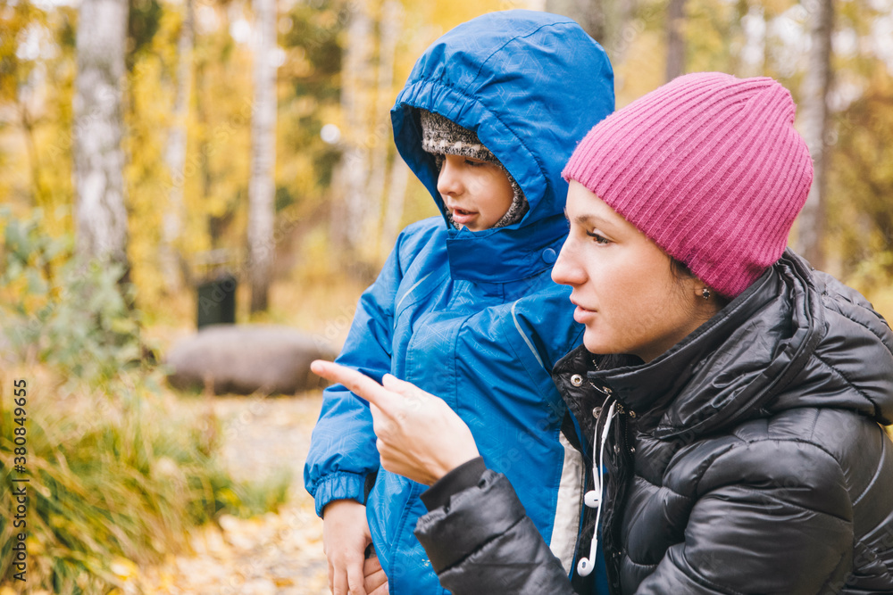 Mother talking to her child while sitting in forest Mother talking to her child while sitting in forest