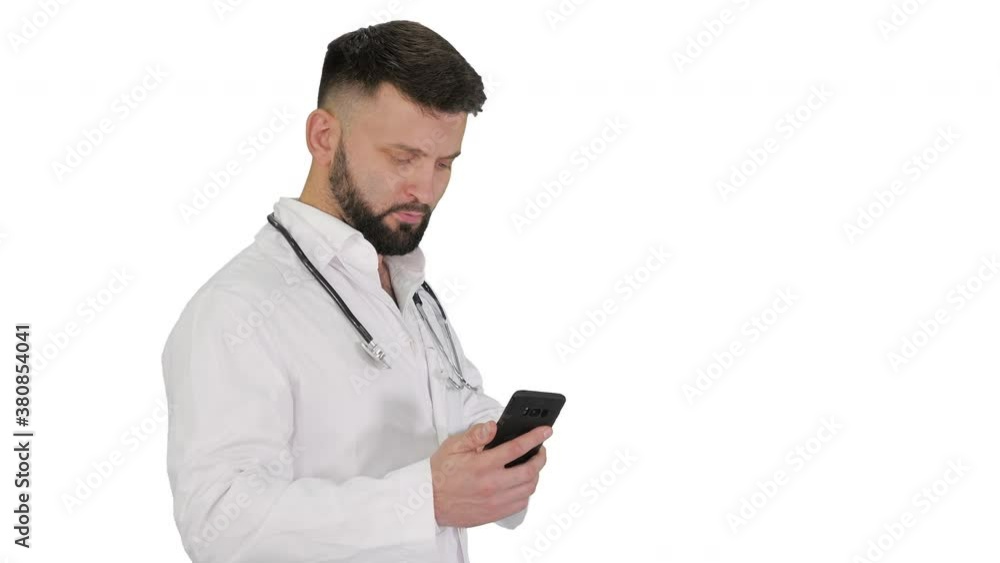 Male doctor in white medical uniform walking and using smartphone on white background. Male doctor in white medical uniform walking and using smartphone on white background.