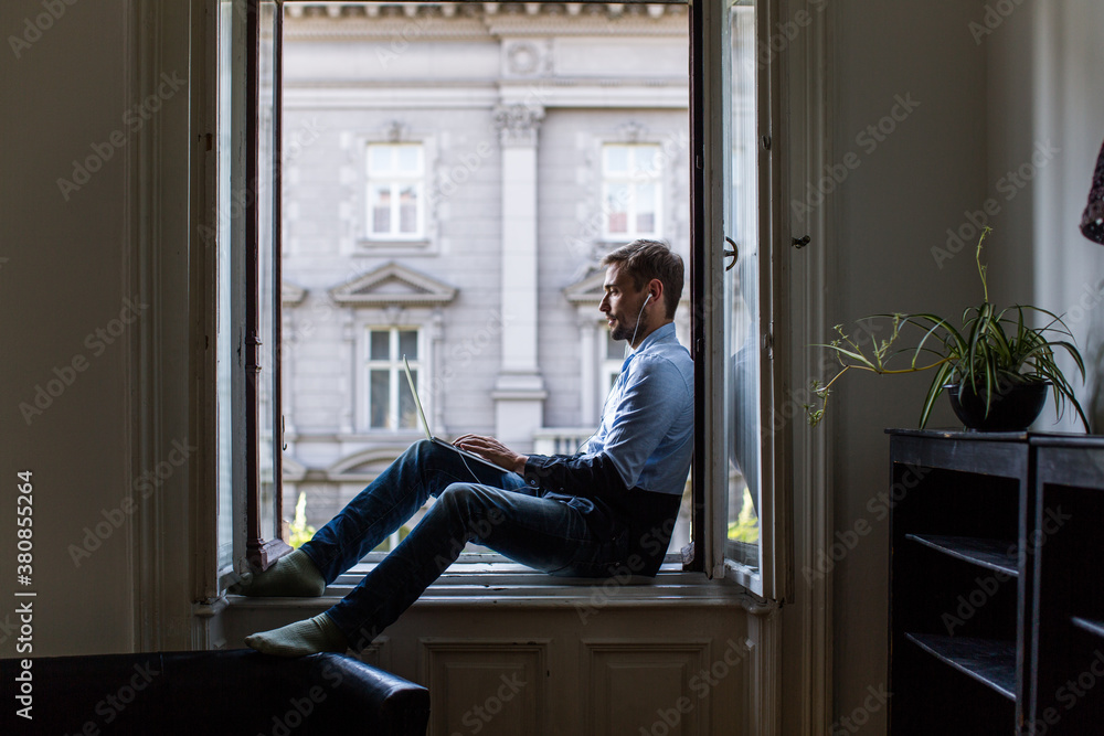 Man sitting at the window and working on a computer Man sitting at the window and working on a computer