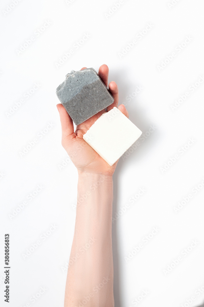Woman holding natural handmade soap bar on white cloth background