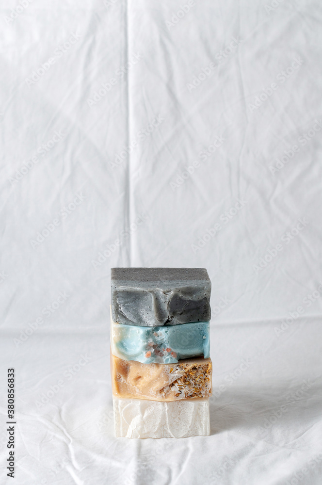 Four types of natural handmade soap bar on white cloth background