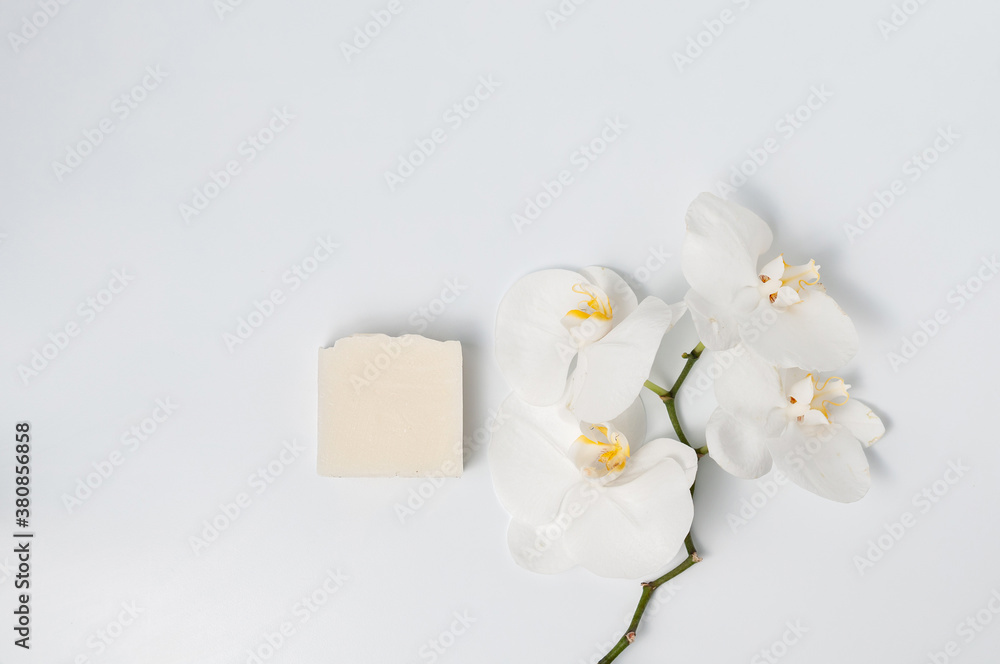 Natural handmade soap bar with orchid flowers on white table