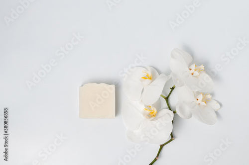 Natural handmade soap bar with orchid flowers on white table