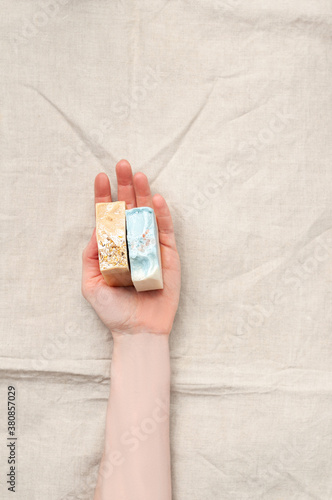 Obraz na płótnie Woman holding natural handmade soap bar on linen fabric background w salonie