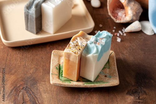 Obraz na płótnie Natural handmade soap bar in ceramic soap dish with spa accessories on wooden table w salonie