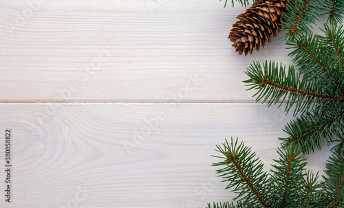 Christmas fir tree with pinecones on a white wooden board and copy space for your text. Banner.Flat lay © syhin_stas