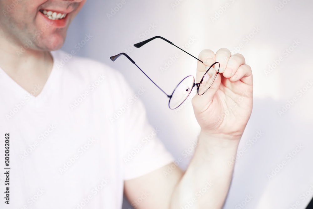 The concept of poor vision. Hold a contact lens and glasses in hand. A poster for advertising glasses and lenses. The concept of poor vision. Hold a contact lens and glasses in hand. A poster for advertising glasses and lenses.
