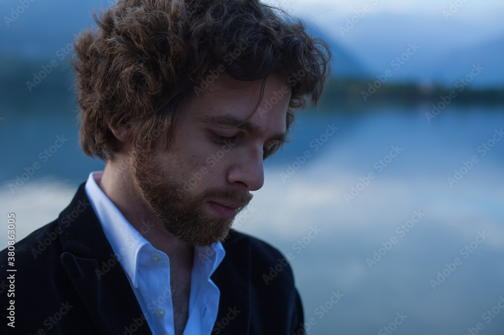 A young handsome man looking down, pensive. A young handsome man looking down, pensive.