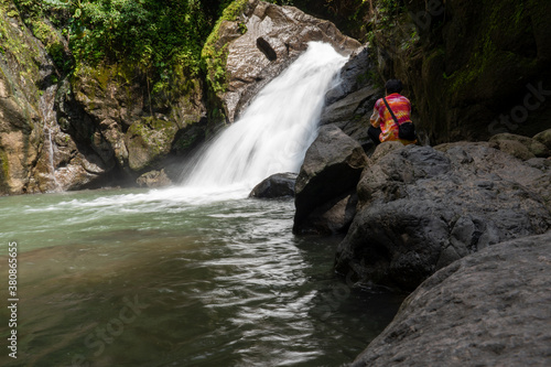 Male traveler Sit and look at the waterfalls in the Thailand National Park.