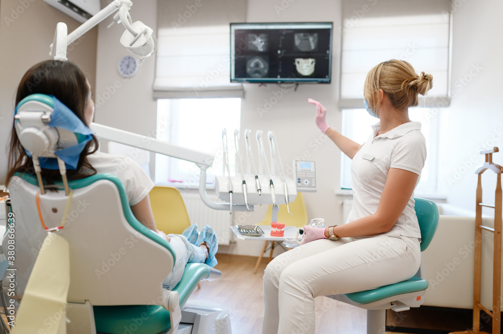 Female dentist shows to patient x-ray of teeth Female dentist shows to patient x-ray of teeth
